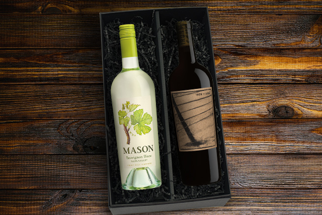 Bottles of Mason sauvignon blanc and iron and sand cabernet sauvignon in a black gift box on a dark wood surface