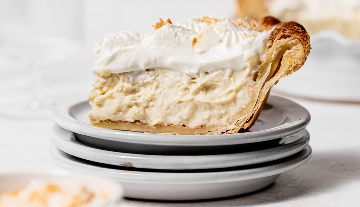 a slice of deep dish coconut cream pie on a small plate